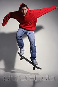 PictureIndia - young man wearing red hooded sweatshirt on skateboard