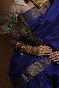 PictureIndia - Torso of Indian woman holding peacock feathers