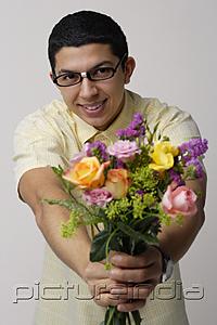 PictureIndia - Young man holding bouquet of flowers