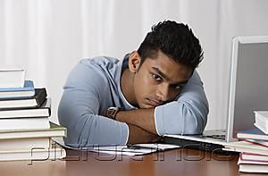 PictureIndia - young man sitting at his desk, moody