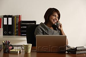 PictureIndia - business woman talking on the phone at office desk