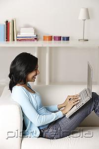 PictureIndia - woman sitting on couch, using laptop