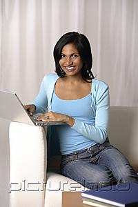 PictureIndia - woman sitting on couch using laptop