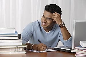 PictureIndia - young man sitting at his desk, writing