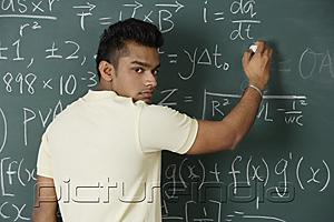 PictureIndia - young man writing formulas on chalk board