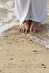 PictureIndia - Close up of feet on the shore