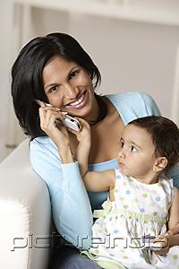 PictureIndia - woman talking on mobile phone, baby on her lap