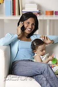 PictureIndia - woman talking on mobile phone, sitting with baby