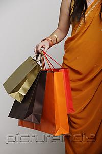 PictureIndia - Woman wearing sari holding shopping bags