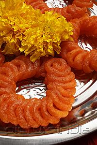 PictureIndia - Close up of Indian sweets with flowers.