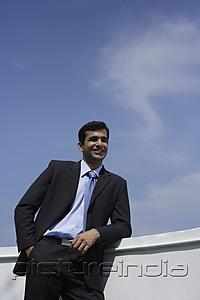 PictureIndia - Indian businessman leaning on balcony.