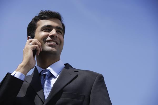PictureIndia - Indian businessman talking on phone outside.