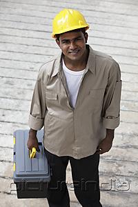 PictureIndia - man wearing construction hat and holding tool box and smiling