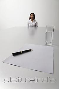 PictureIndia - Young woman sits at end of the table waiting to be interviewed