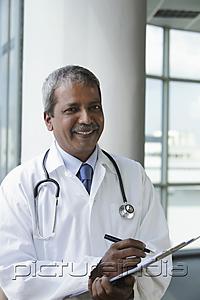 PictureIndia - Indian doctor writing  on clipboard