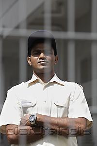 PictureIndia - Security guard looking from behind fence