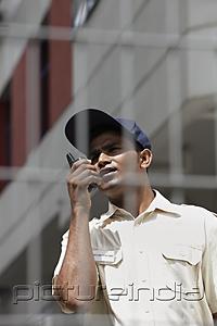 PictureIndia - Security guard talking on walkie talkie