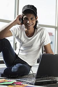 PictureIndia - young man wearing headphones while on laptop