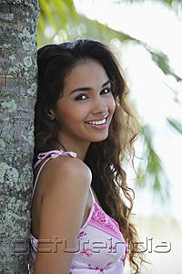 PictureIndia - young woman leaning next to tree and smiling