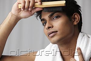 PictureIndia - head shot of young man brushing his hair