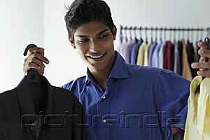 PictureIndia - young man deciding between two shirts