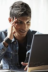 PictureIndia - young man looking at laptop and smiling