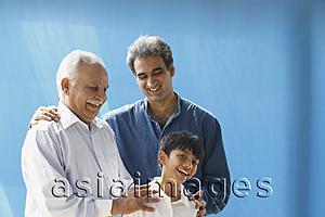 Asia Images Group - Grandfather, father, son laughing, blue background