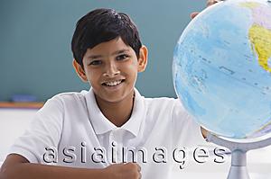 Asia Images Group - boy smiles at camera with globe