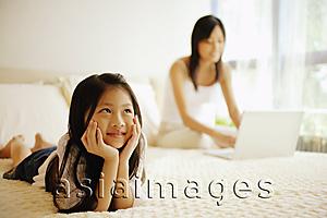 Asia Images Group - Mother and daughter in bedroom, mother using laptop
