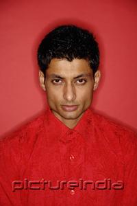 PictureIndia - Man looking at camera, wearing red shirt