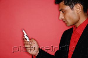 PictureIndia - Man looking at handphone, sideview