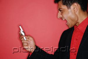 PictureIndia - Man looking at handphone, mouth open, profile