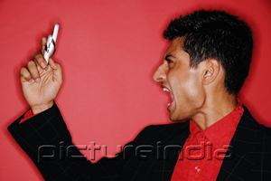 PictureIndia - Man looking at handphone, mouth open, shouting