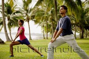 PictureIndia - Young adults doing exercises in park.