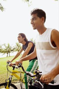 PictureIndia - Two young men on bicycles, side by side, looking away