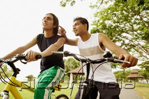 PictureIndia - Two young men on bicycles, one pointing