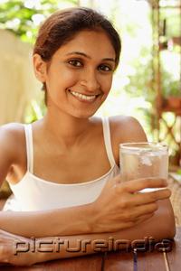 PictureIndia - Woman holding glass of water, smiling