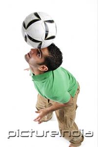 PictureIndia - Young man balancing soccer ball on his head