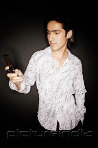 PictureIndia - Young man looking at mobile phone