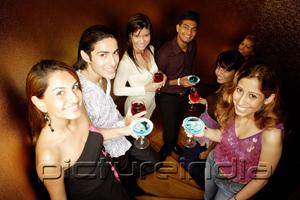 PictureIndia - Young adults holding drinks, looking at camera