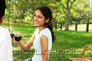 PictureIndia - Couple in park, toasting with wine glasses