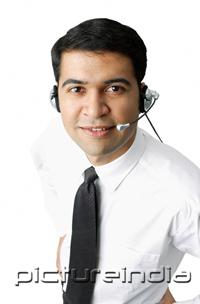 PictureIndia - Executive wearing headset, looking at camera