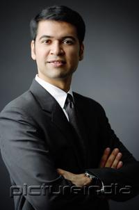 PictureIndia - Businessman looking at camera, arms crossed, portrait