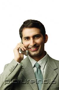 PictureIndia - Businessman using mobile phone, facing camera