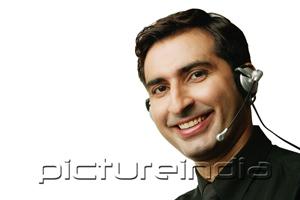 PictureIndia - Man using headset, head shot