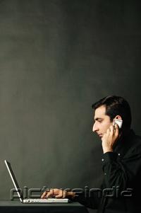 PictureIndia - Man using laptop and using mobile phone