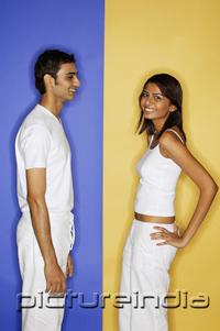 PictureIndia - Couple standing apart, woman with hand on hip, turning to look at camera