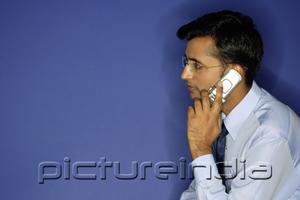 PictureIndia - Man using mobile phone, side view