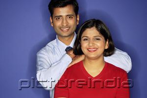 PictureIndia - Couple smiling at camera, man behind woman