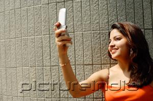 PictureIndia - Woman taking a photo using mobile phone